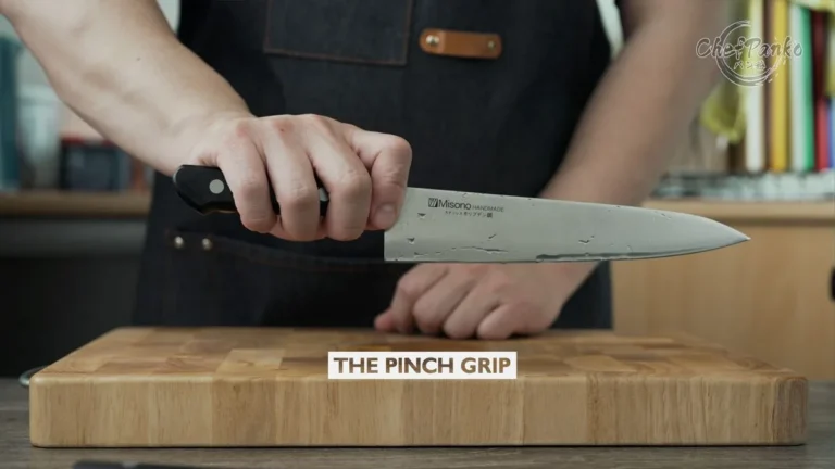 How should you hold a kitchen knife?